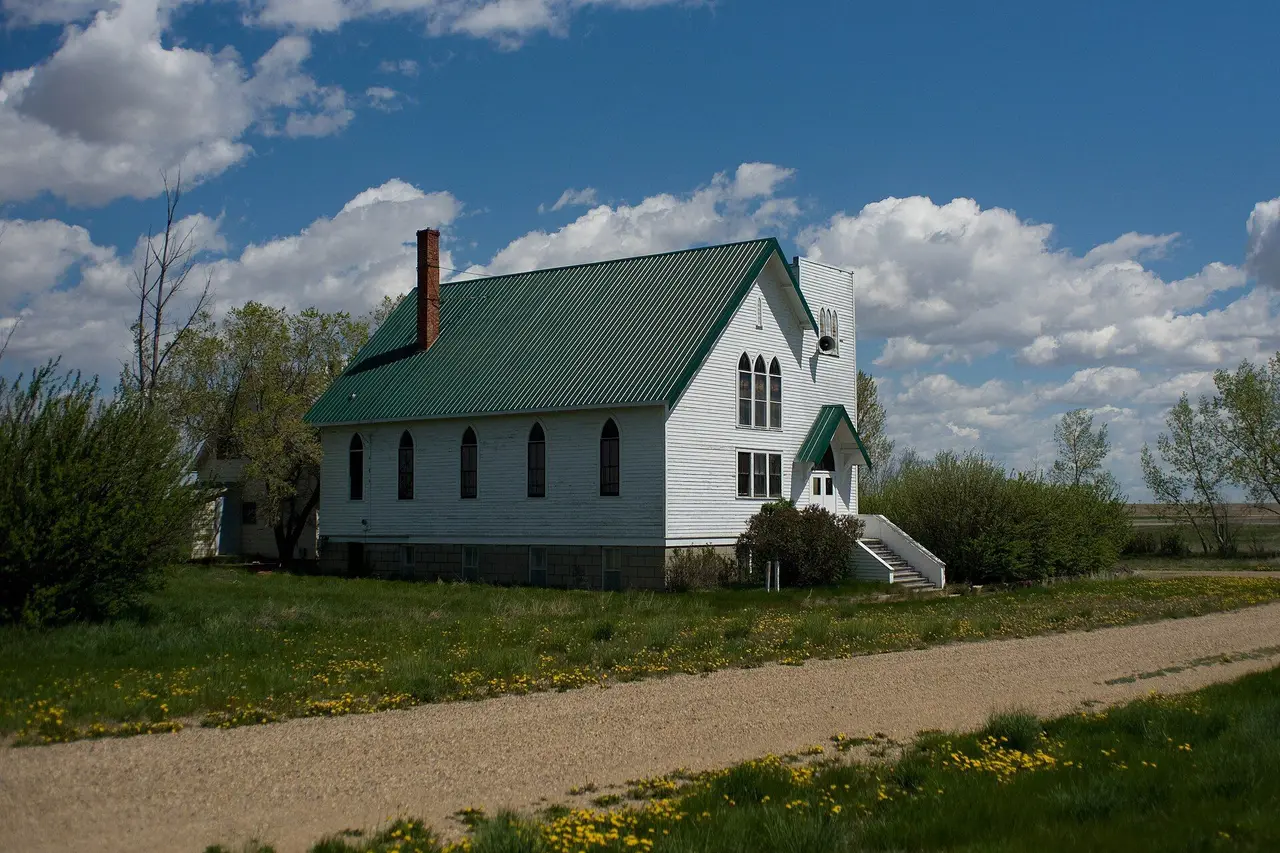 White church with green roof on a gravel road, 2009
